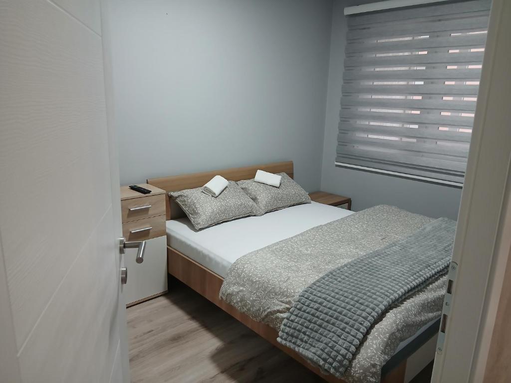 ein kleines Schlafzimmer mit einem Bett und einem Fenster in der Unterkunft Apartman Mirjana in Sarajevo