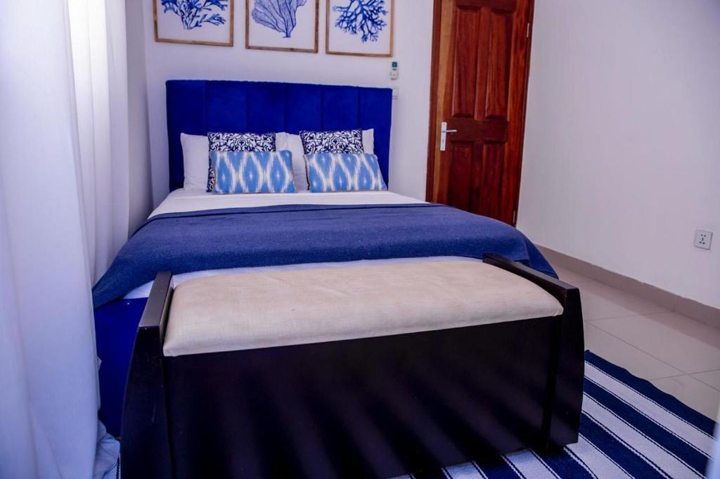- une chambre dotée d'un lit bleu avec des draps et des oreillers bleus dans l'établissement Alojamento Local - Amor e Mar, à Luanda
