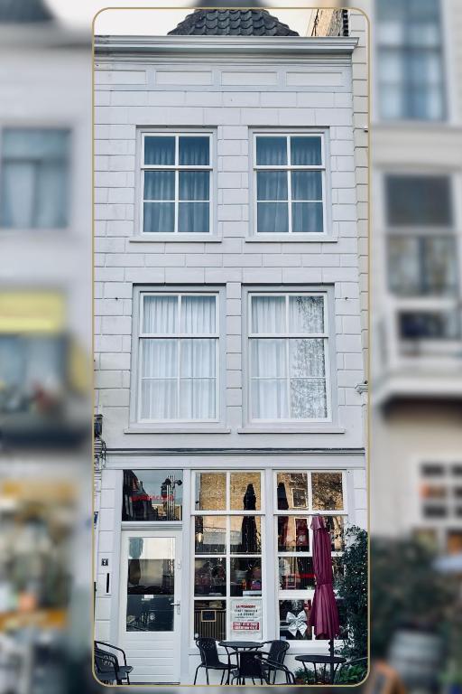 a white building with a table and chairs in front of it at Bedroom Dordrecht Centrum - La Focaccina in Dordrecht