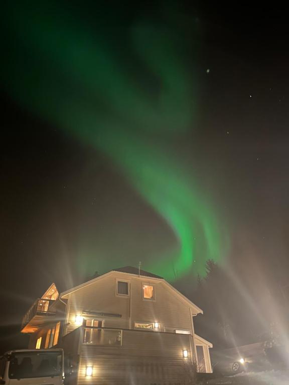una casa con un'aurora verde nel cielo di 2 bedrooms apartment in Tønsvika a Tromsø