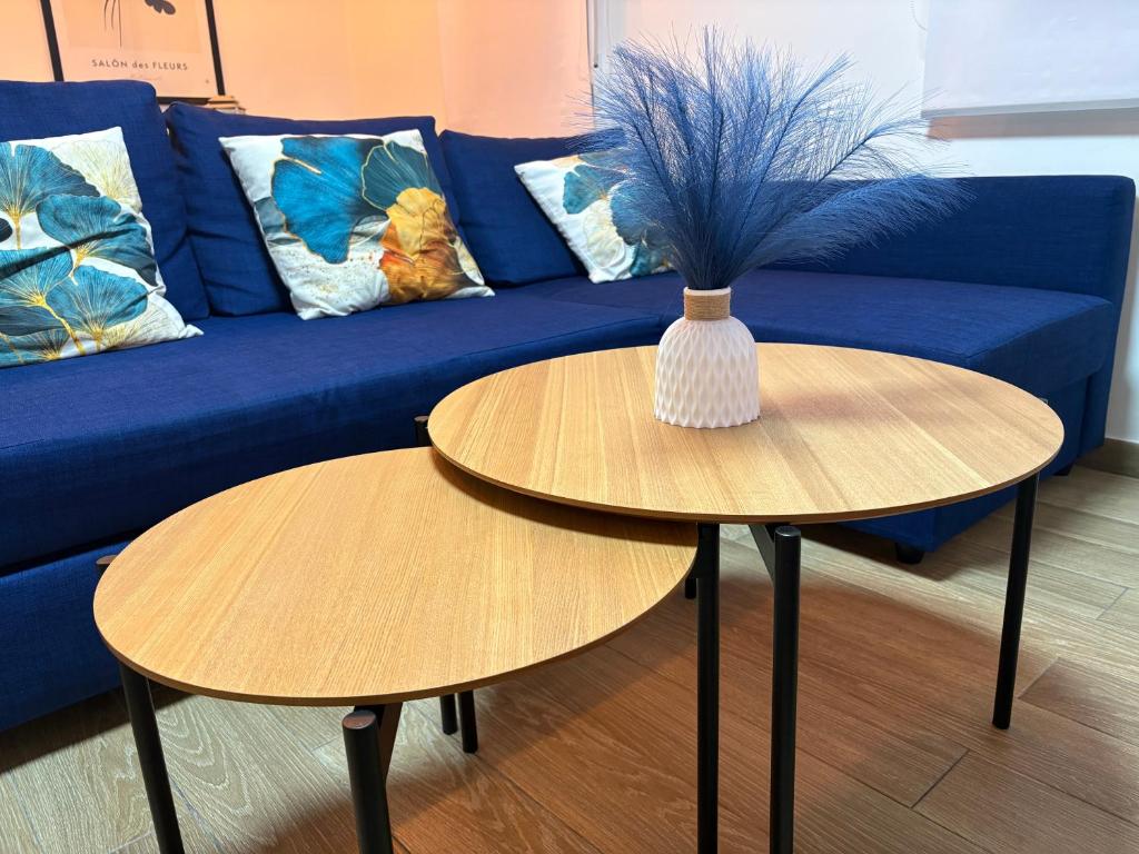 un divano blu e due tavoli con un vaso sopra di El Pisito a Ontinyent