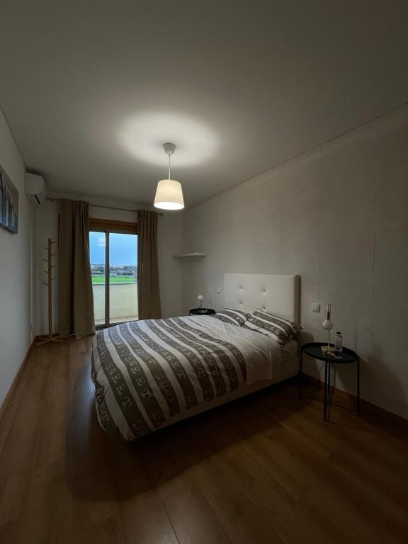 een slaapkamer met een groot bed en een raam bij Alojamento Local Pando in Aveleda