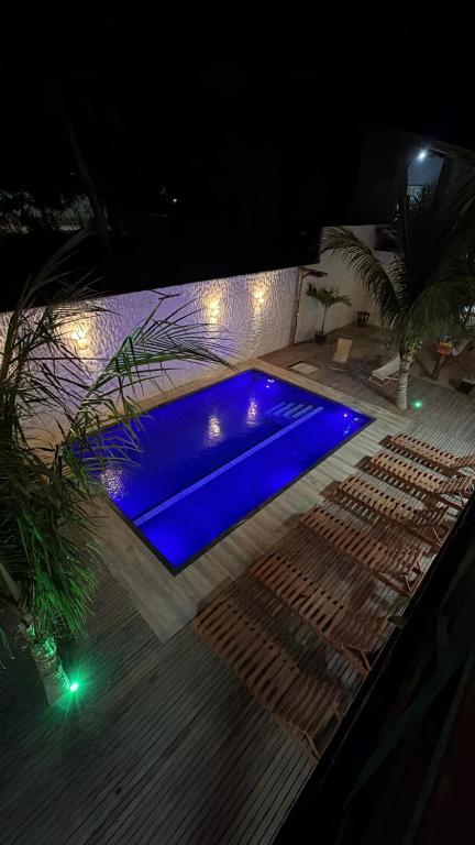 a blue swimming pool with lights on the floor at night at Kairos Beach Hotel in Camocim