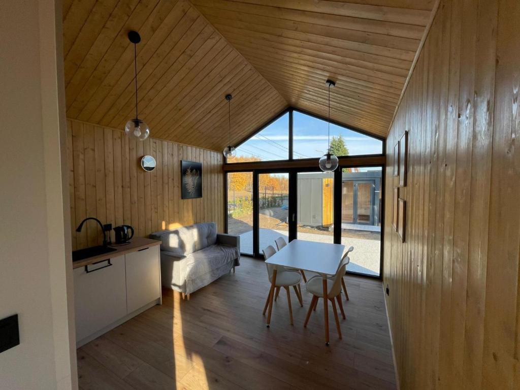 een keuken en woonkamer met een tafel en stoelen bij Pochyła 80 home&spa in Rybnik