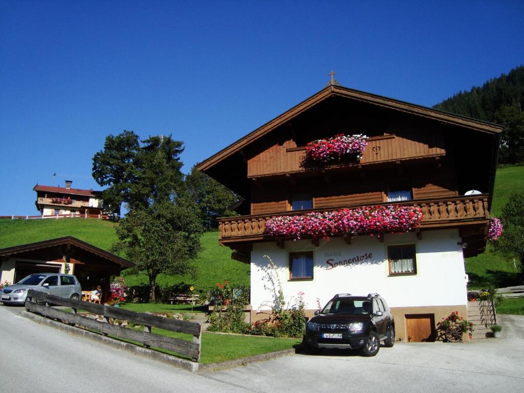 una pequeña casa con flores a un lado. en Haus Sonnenrose, en Oberau