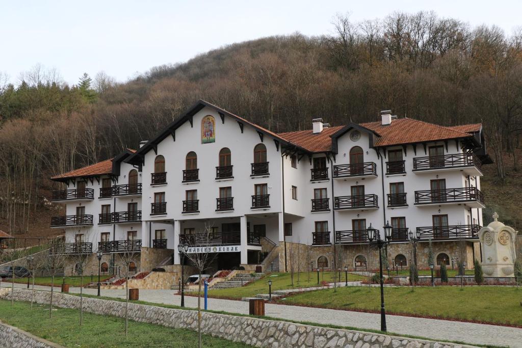 een groot wit gebouw met een heuvel op de achtergrond bij Tumanski Konak, Natalije Dugošević 17 in Golubac