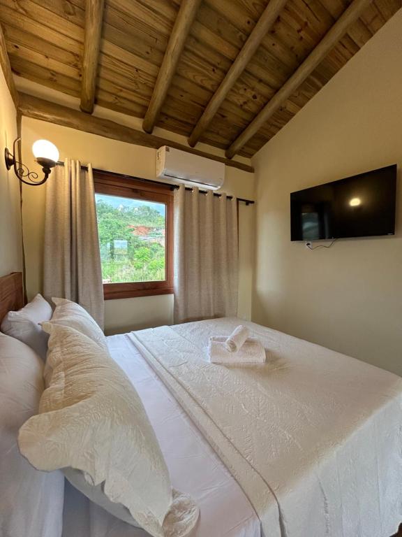 En eller flere senge i et værelse på Chalé Doce Vida