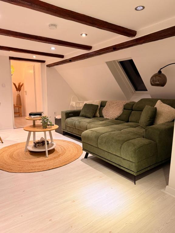 een woonkamer met een groene bank en een tafel bij Waldruhe Bad Steben in Bad Steben