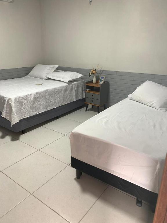 two beds sitting next to each other in a bedroom at Chalé Sol e Luar 3 Ambientes in Santo Amaro