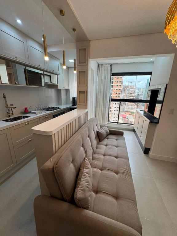 un grand canapé au milieu d'une cuisine dans l'établissement Luxuoso Doce lar com Garagem, à Itapema