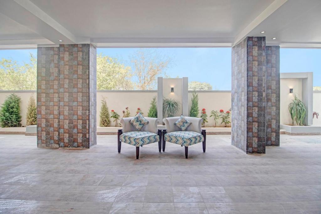 zwei Stühle in einem großen Raum mit Backsteinsäulen in der Unterkunft Collection O Halcyon SS Grand in Hyderabad