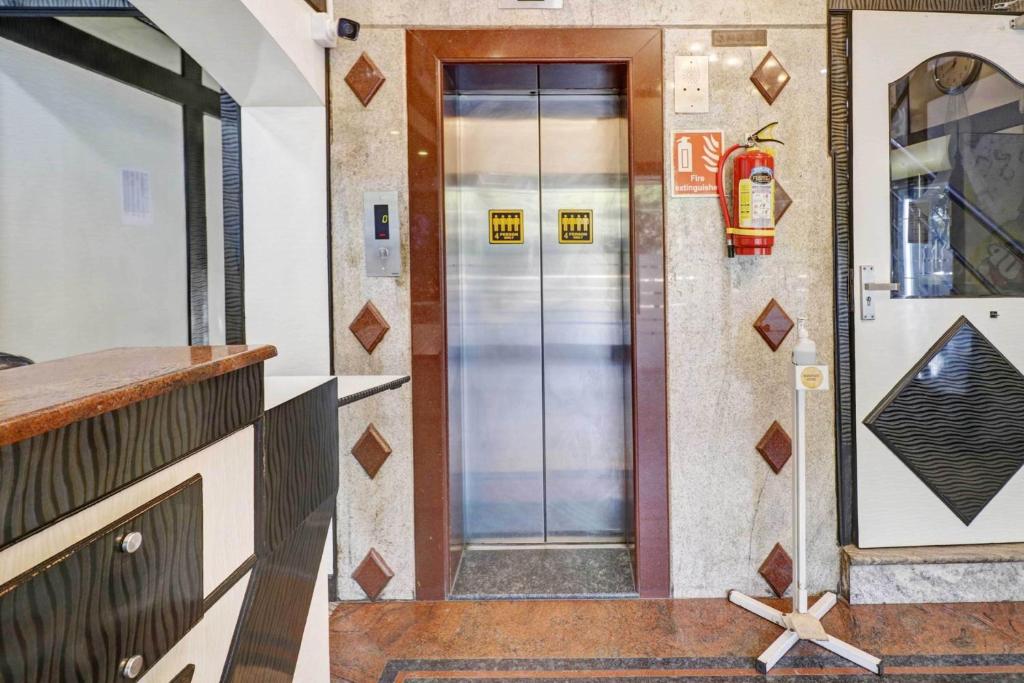 ein Aufzug in einem Gebäude mit einer Glastür in der Unterkunft Collection O Sabharwal Residency Near Lalbagh Botanical Garden in Bangalore