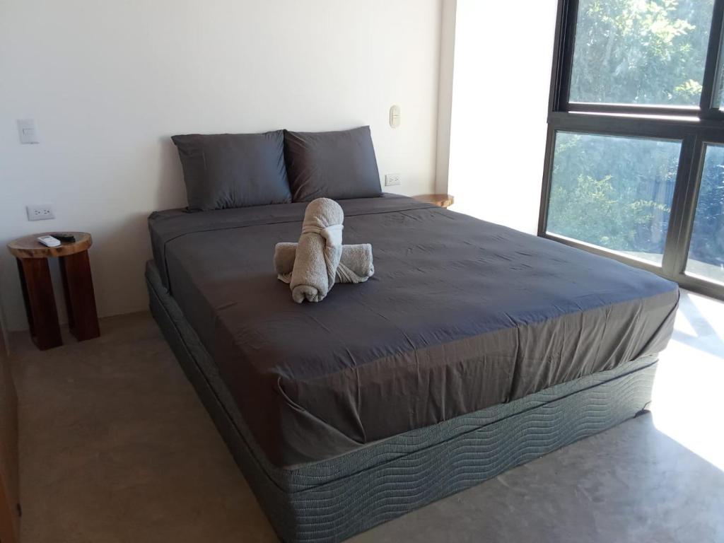 a teddy bear laying on a bed in a bedroom at Jungle surf Villa in El Zonte