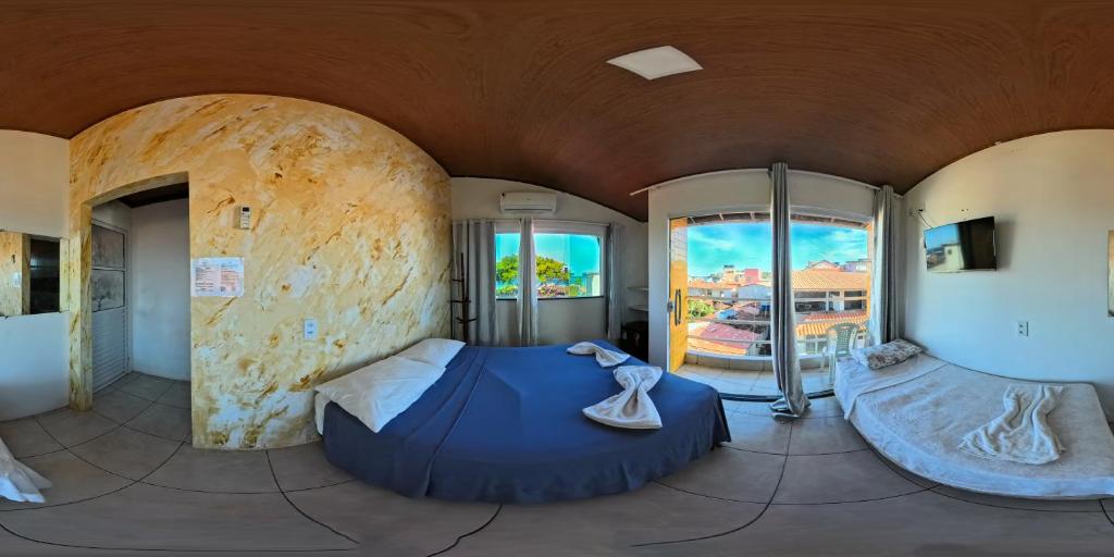 a large room with two beds in it with windows at POUSADA los SABABA in Morro de São Paulo