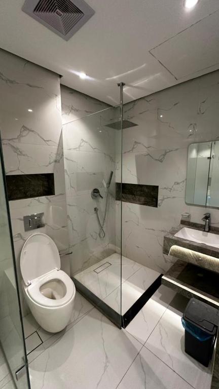a bathroom with a toilet and a shower and a sink at شاليه ايلان المدينة المنورة in Medina