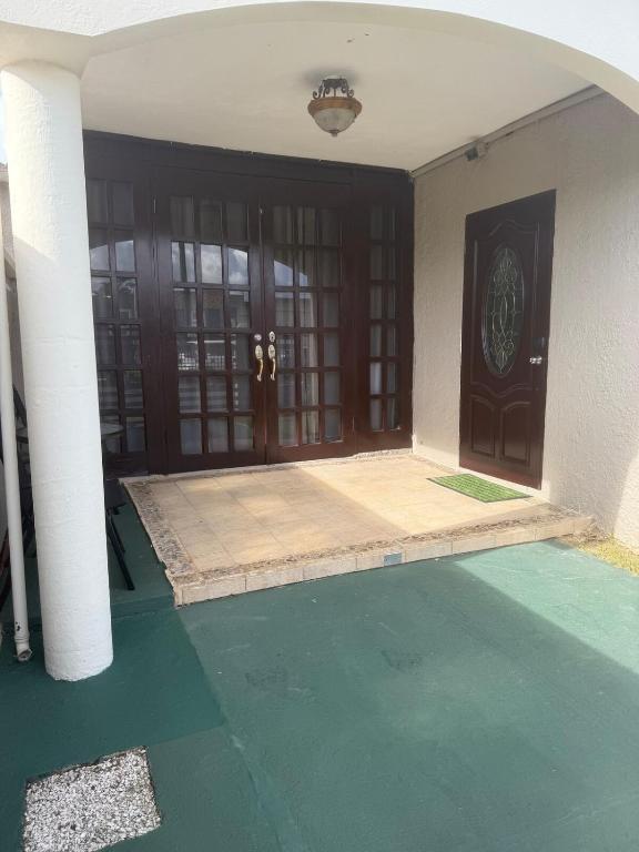 an entrance to a house with a green floor and columns at Caguas Like Home in Caguas