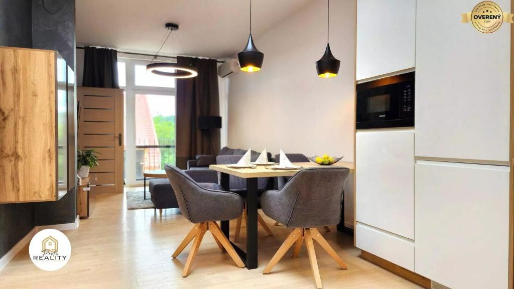 a kitchen and dining room with a table and chairs at Mezonet Jarková in Prešov