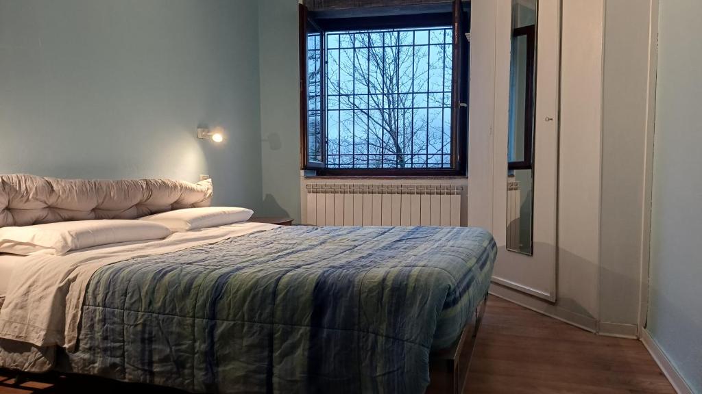 ein Schlafzimmer mit einem großen Bett mit Fenster in der Unterkunft La Tavernetta in Ponte della Venturina