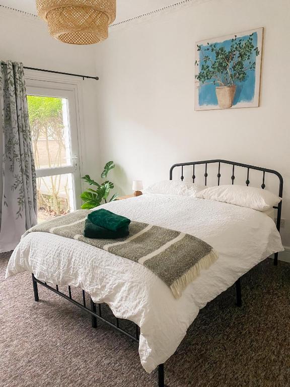 ein Schlafzimmer mit einem Bett mit weißer Bettwäsche und einem Fenster in der Unterkunft Cozy home in Kings Lynn