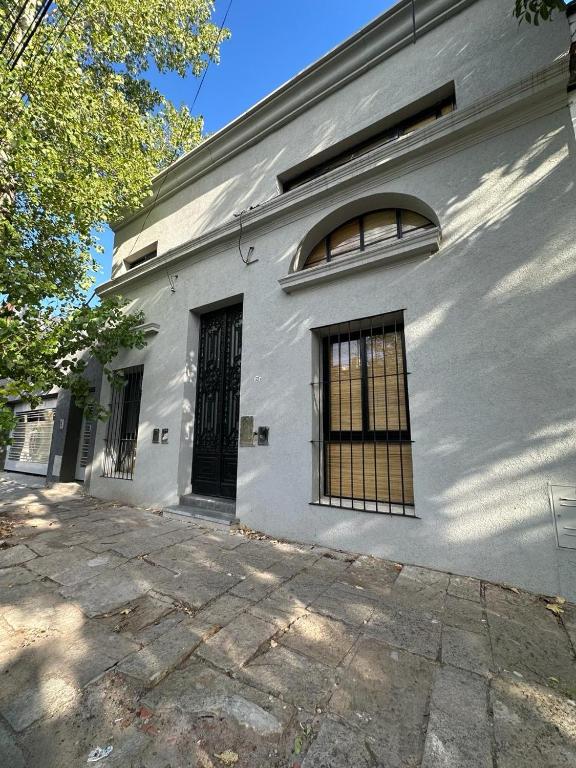 a white building with two windows and a door at Departamento Loft Costanera in Gualeguaychú