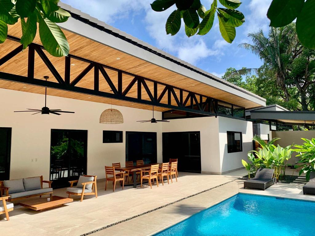 an outdoor patio with a table and chairs and a pool at Honu Villas - Nui in Nosara