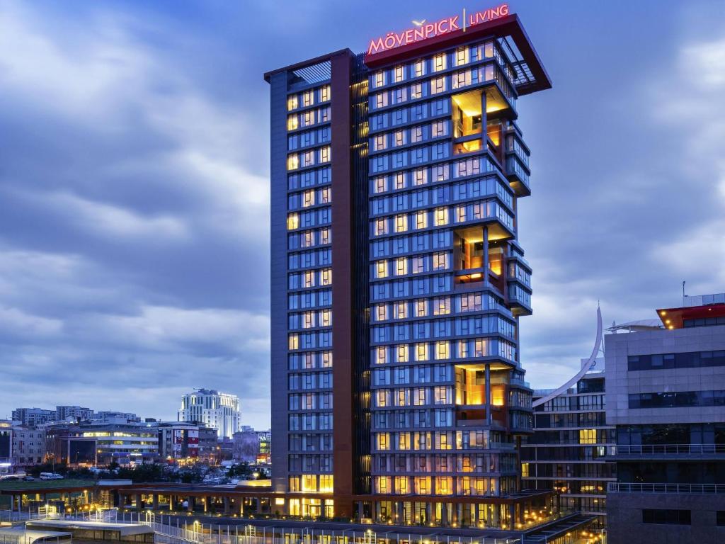 een hoog gebouw met een bord erop bij Movenpick Living Istanbul West in Istanbul