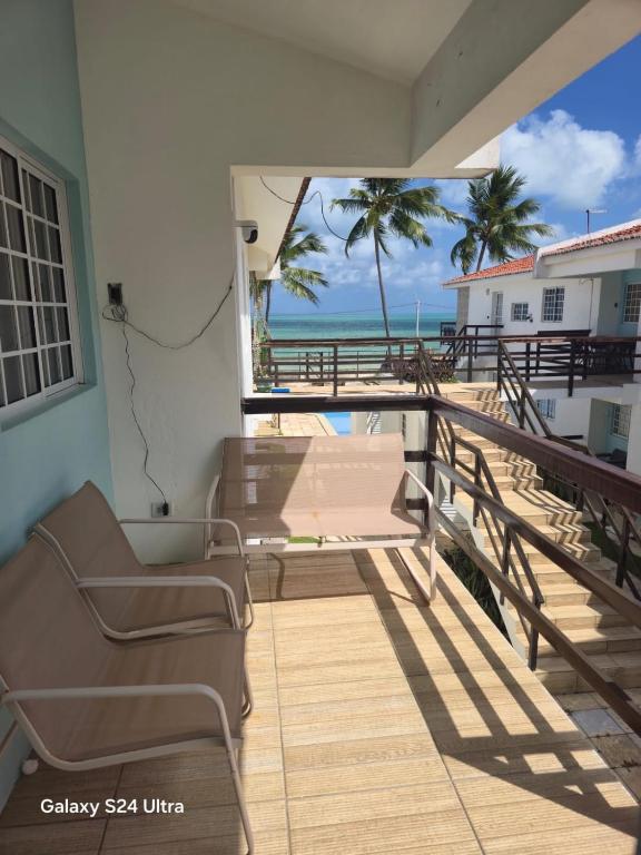 a balcony with chairs and a view of the beach at Flat aconchegante em Itamaracá in Itamaracá