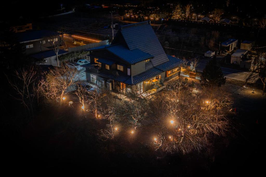 een luchtfoto van een huis 's nachts met verlichting bij KOS Restaurant & Hotel in Fujikawaguchiko