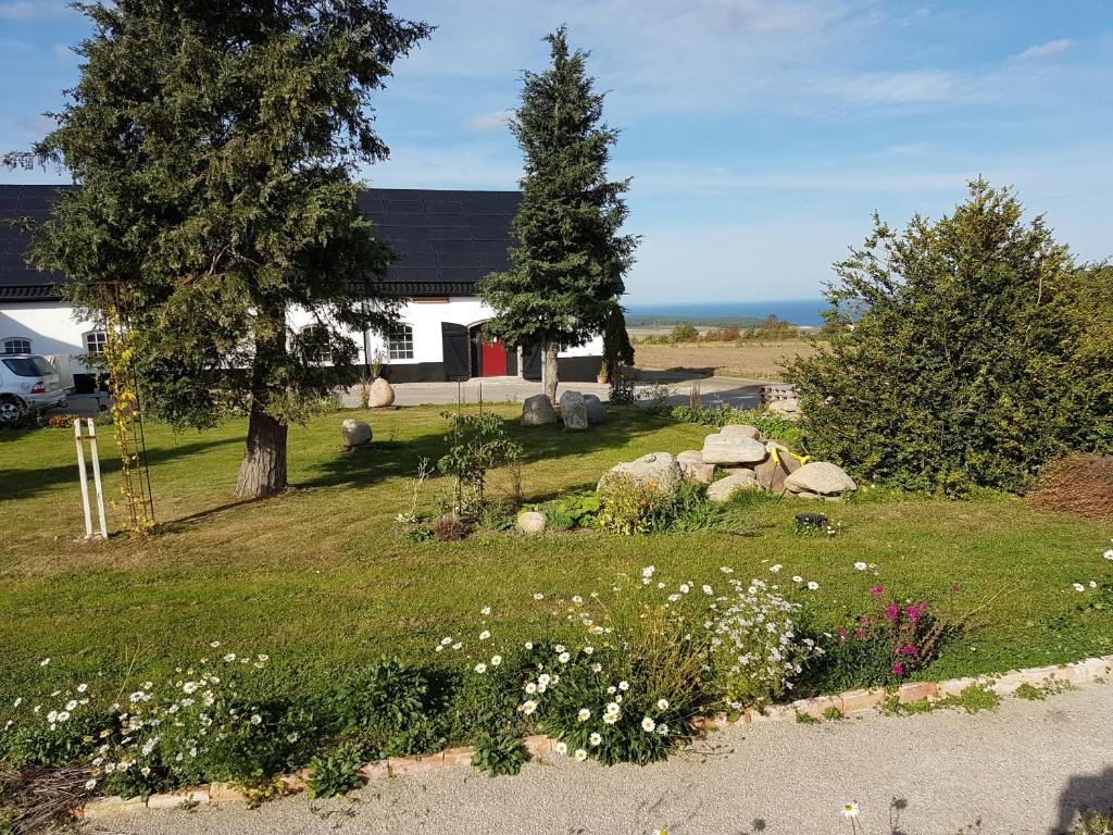 un patio con flores y árboles y una casa en Bästekille Gårdshotell en Kivik