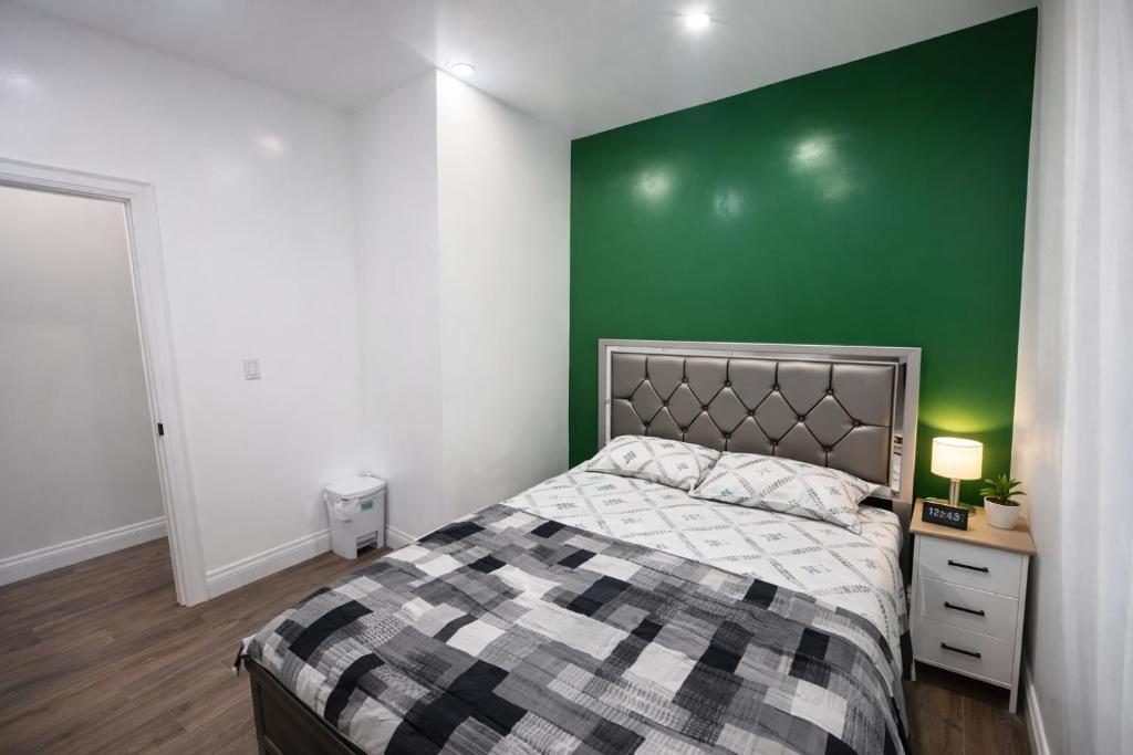 ein Schlafzimmer mit einem Bett und einer grünen Wand in der Unterkunft Private Bathroom Room In Cambridge B7 in Cambridge