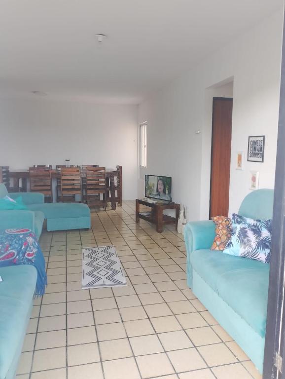 a living room with two blue couches and a table at Apartamento BEIRA MAR - Edifício Mar Del Plata in Itamaracá