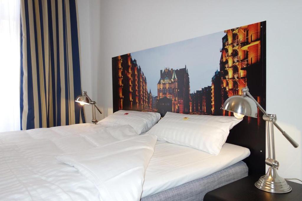 a bed with two white pillows and a painting on the wall at URBAN STAY Hamburg - Apartments Mitten im Herzen von Ottensen in Hamburg