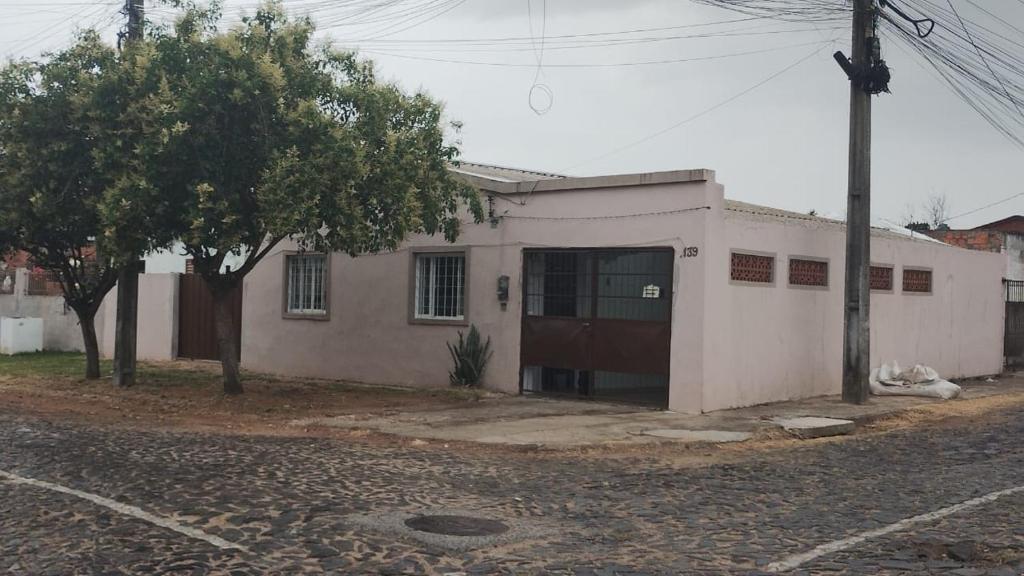 ein kleines weißes Gebäude mit einer Tür auf einer Straße in der Unterkunft Casa da Mariângela in São Gabriel