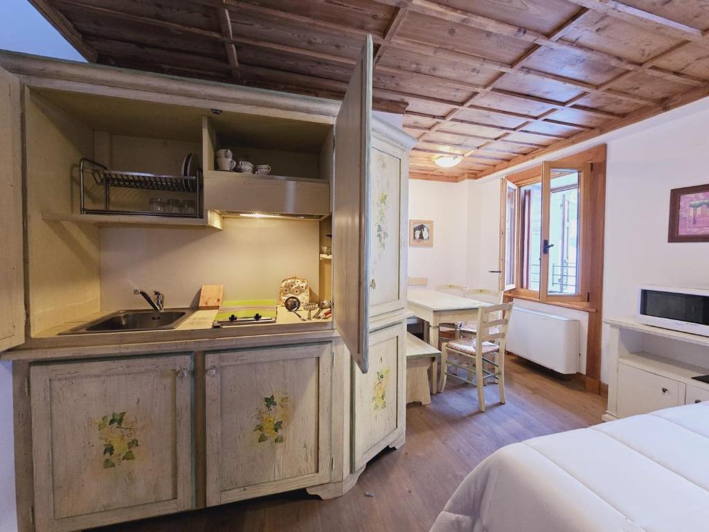 - une cuisine avec un évier et un bureau dans la chambre dans l'établissement Studio apartment with air conditioning, à Ceresole Reale