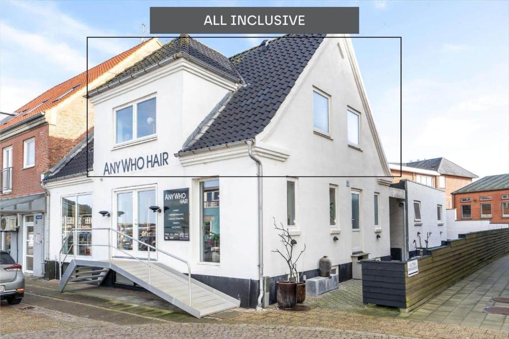 a white building with a sign that reads all inclusive at 890-Hvide-Sande-Bredgade-3-B-1 in Hvide Sande
