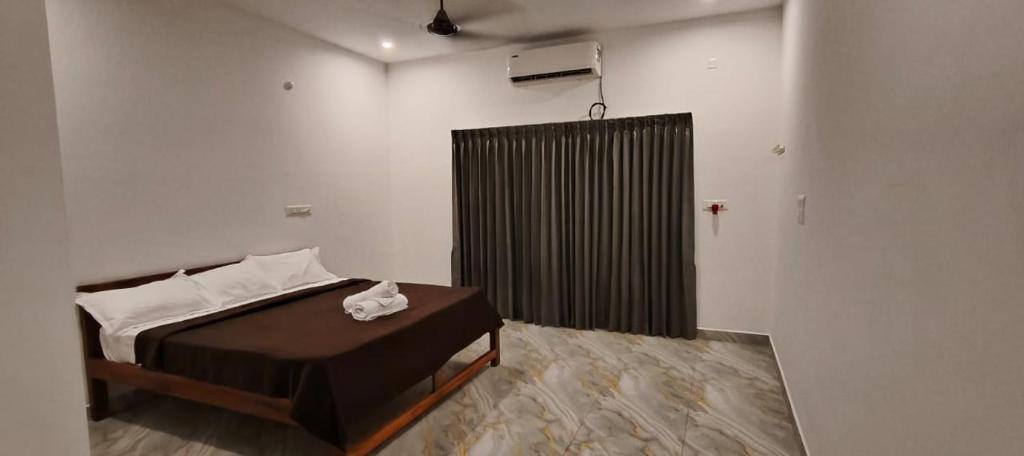 een slaapkamer met een bed en een zwarte douche bij La Nature Retreat in Kuilapayam