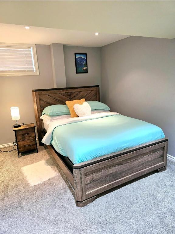 ein Schlafzimmer mit einem großen Bett mit einem hölzernen Kopfteil in der Unterkunft Welcome to your Serene Gateway in London