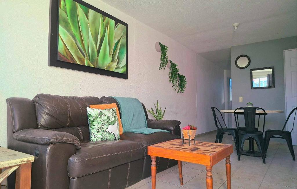 un soggiorno con divano in pelle marrone e tavolo di Casa Veta Qro a Villa del Pueblito