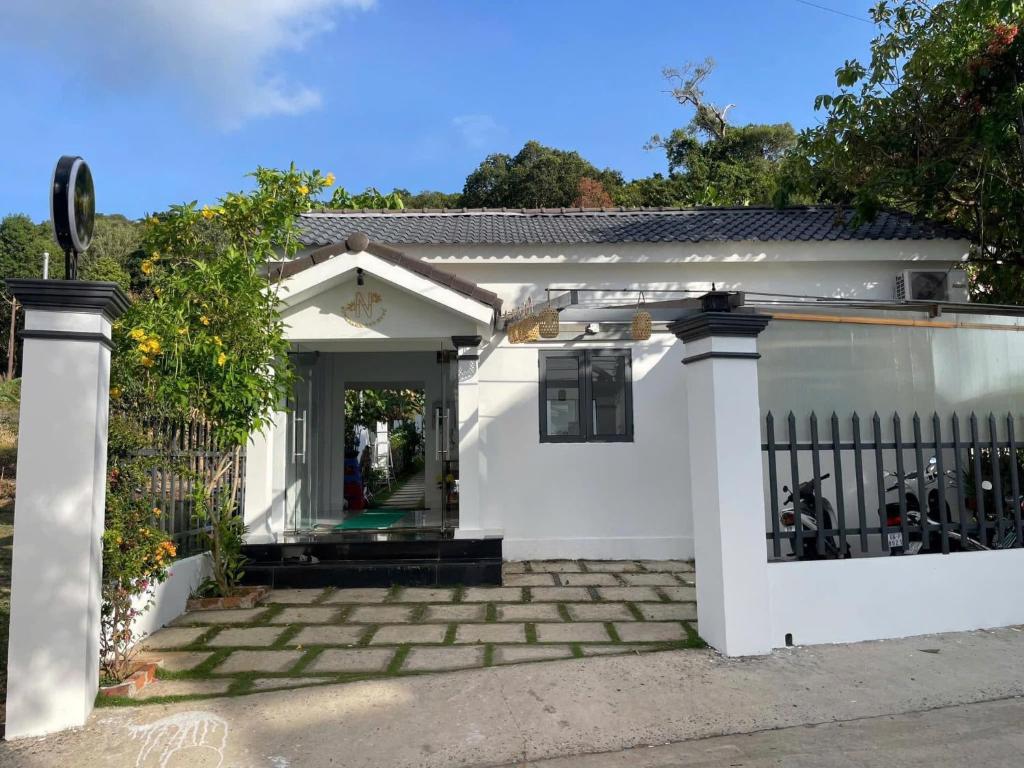 een wit huis met een poort en een oprit bij Phu Quoc Green Bungalow in Phu Quoc