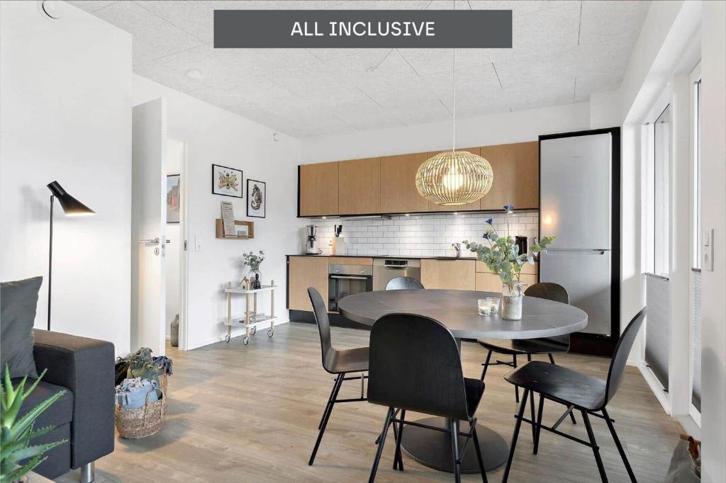 een keuken en eetkamer met een tafel en stoelen bij 908-Hvide-Sande-Langsand-102-stuen in Hvide Sande