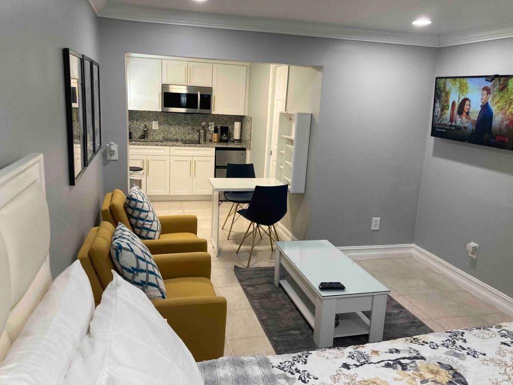 een woonkamer met een bed en een keuken bij sunset cottage in West Palm Beach