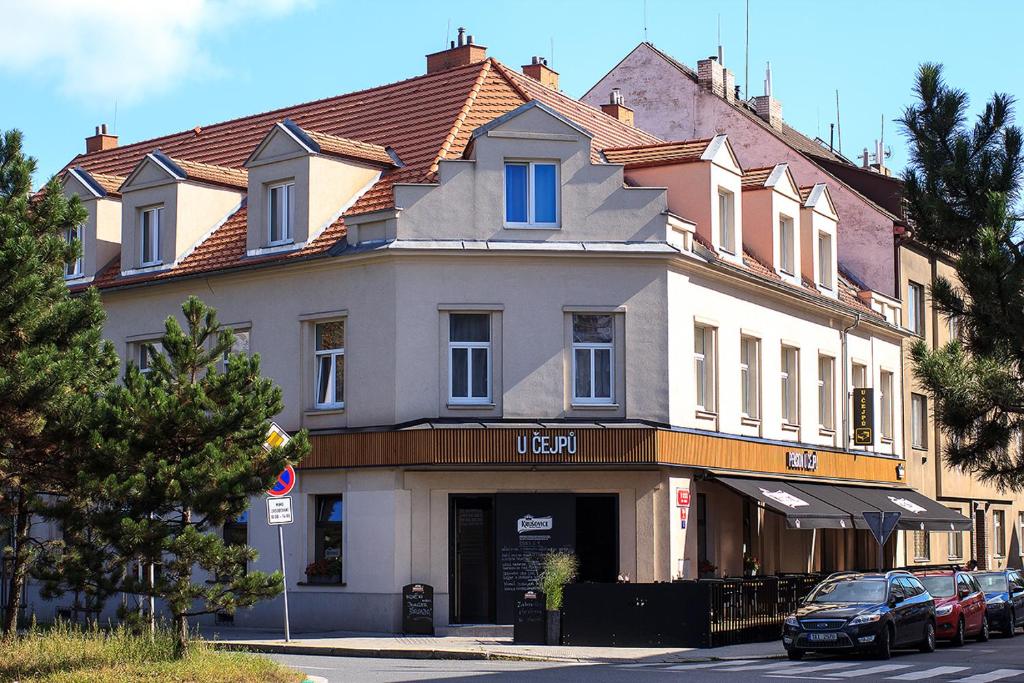 budynek na ulicy z samochodami zaparkowanymi przed nim w obiekcie Penzion U Čejpu w Pradze