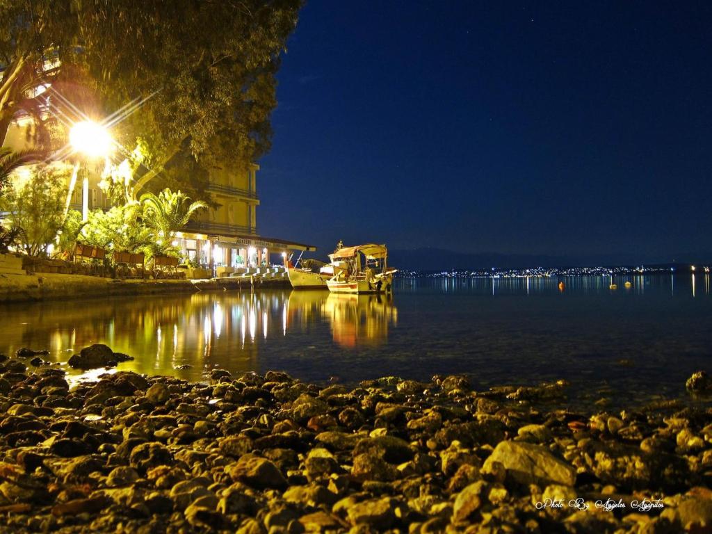 una vista nocturna de un cuerpo de agua con un faro en Hotel Lefkadi, en Lefkandi Chalkidas