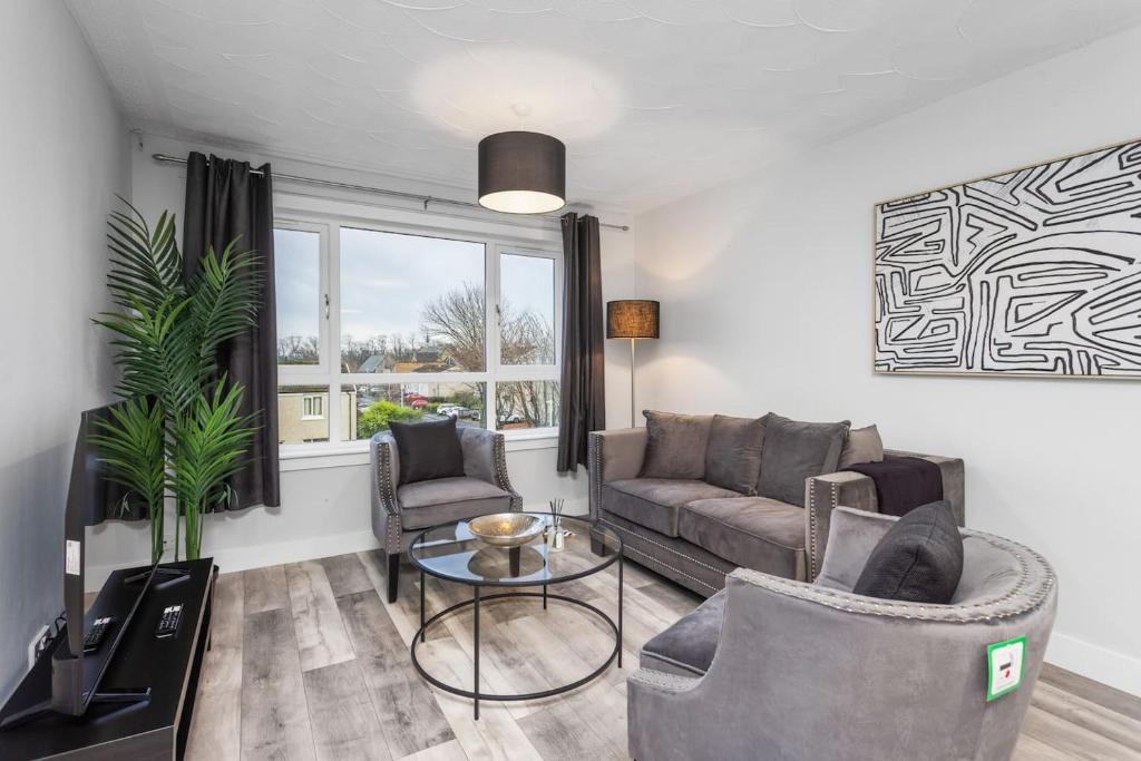 a living room with a couch and a table at Well Presented 3 Bedroom, Grangemouth. in Falkirk