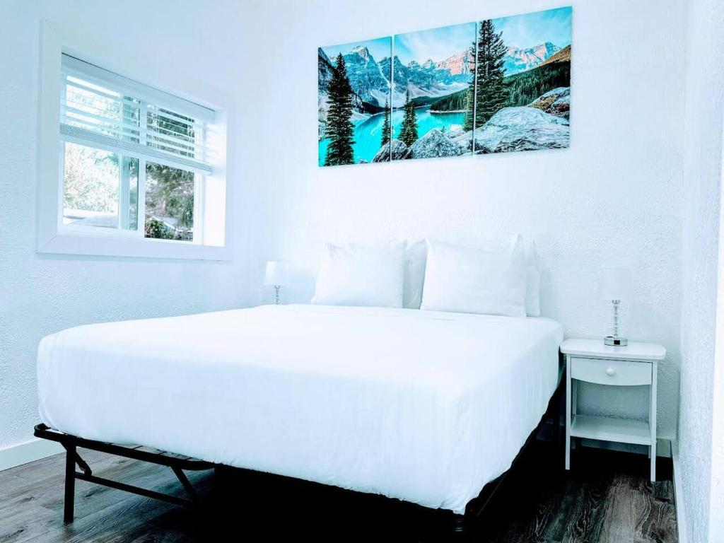 a white bedroom with a large white bed and a window at The Sitka Studio in Forks