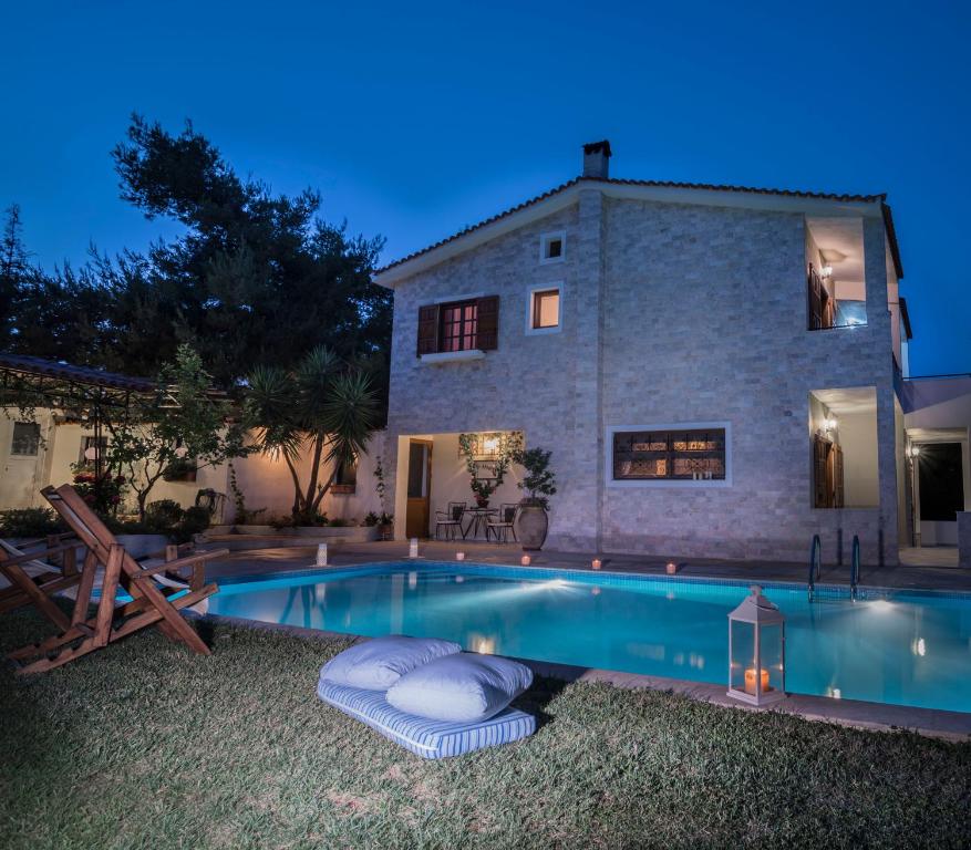 Villa Corina near the Airport في Kouvarás: منزل أمامه مسبح