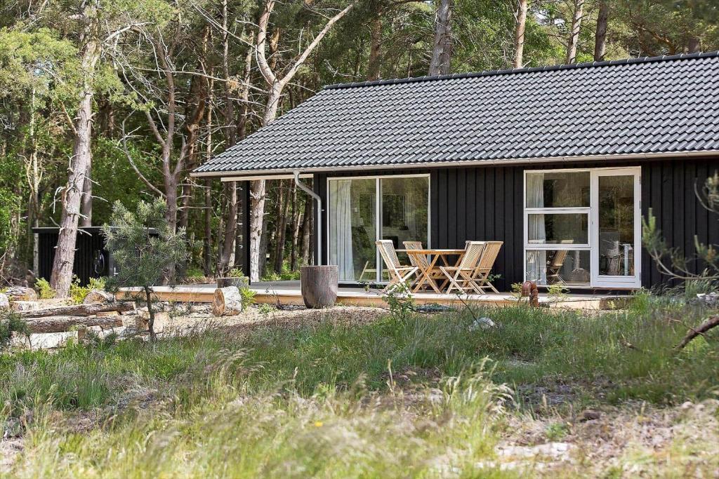 a small black house with a table and chairs outside at 2309-Stege-Enebaerstien-39 in Stege