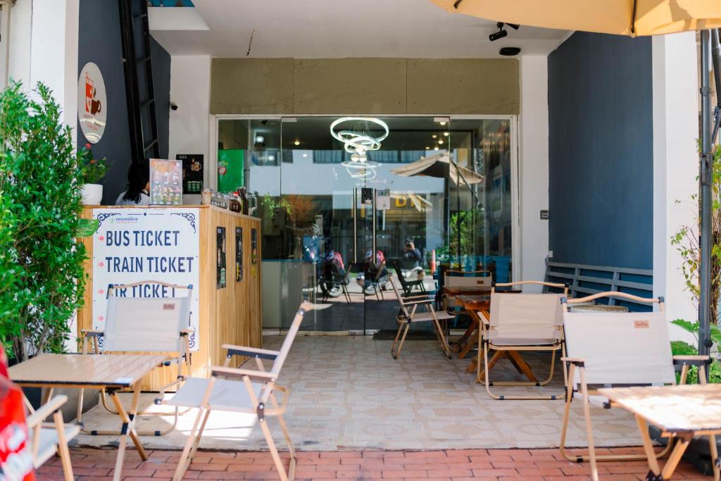 een restaurant met tafels en stoelen voor een gebouw bij Happyhome Hostel in Ban Pho Touane