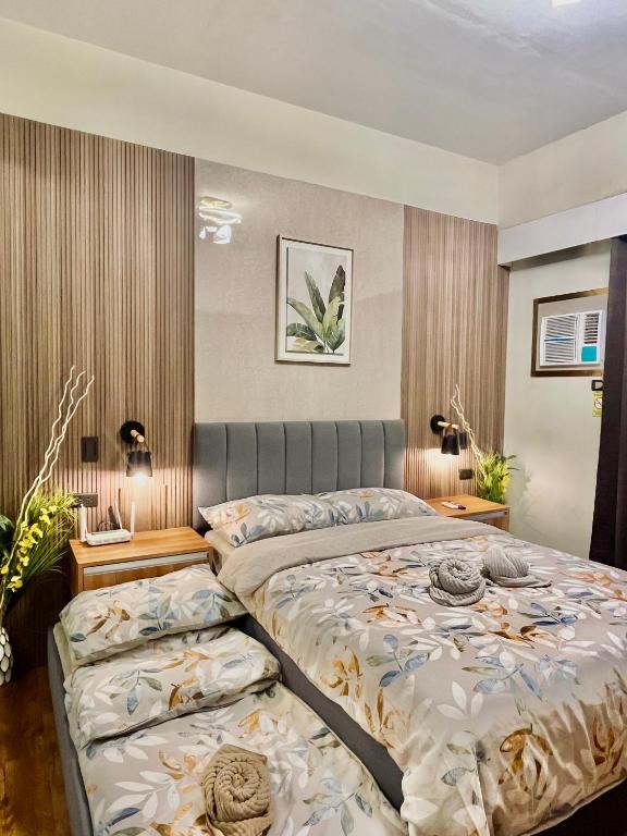 a bedroom with two beds and two night stands at Amani Grand Resort Residences Pool Netflix Gym near Airport in Lapu Lapu City