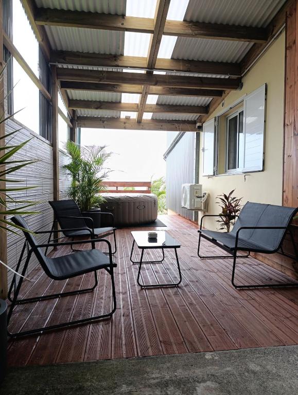 a patio with chairs and a table on a deck at Du Pure Cocooning in Saint-Philippe